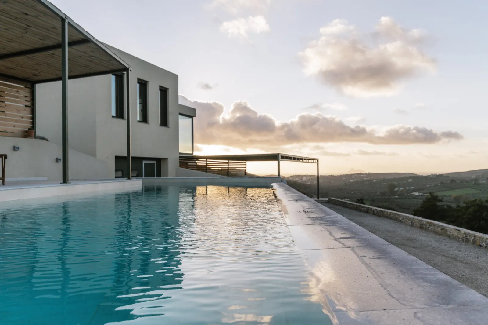 The shared infinity pool at sunset with the Main House behind